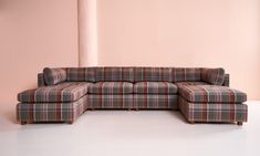 a checkered sectional sofa in front of a pink wall