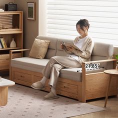 a woman sitting on a couch reading a book in a living room with bookshelves