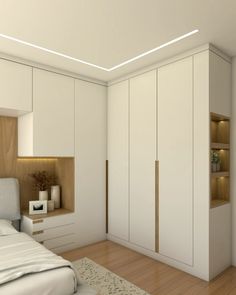 a bedroom with white cupboards and wooden flooring