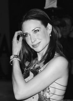 a beautiful young woman posing for the camera with her arm around her head and wearing bracelets