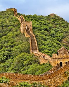 the great wall of china with people walking up and down it's steep incline