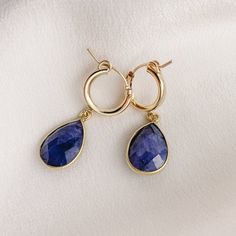 Simple and sweet, these hoop earrings feature small pear-shaped gemstone charms that are faceted on both sides. We've got gemstones for every month of the year. -- charms: 18mm 14k Gold Filled hoop diameter: 13mm secure latch back closure bezel frame: 22k gold plated sterling silver available gemstones: 12 hydrothermal quartz stones Note: moonstone - natural gemstone Handmade Teardrop 14k Gold Hoop Earrings, Everyday Teardrop Huggie Earrings, Hypoallergenic Teardrop Huggie Earrings Fine Jewelry, Fine Jewelry Hypoallergenic Teardrop Hoop Earrings, Fine Jewelry Teardrop Huggie Earrings Gift, Faceted Teardrop 14k Gold Earrings, Everyday Teardrop Faceted Earrings, Handmade Teardrop Huggie Earrings For Gift, Hypoallergenic Teardrop Hoop Earrings In Fine Jewelry Style