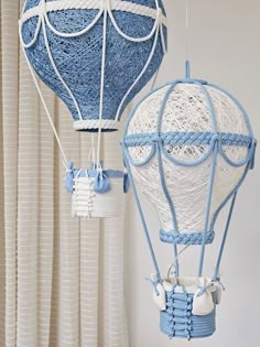 two blue and white hot air balloons hanging from strings