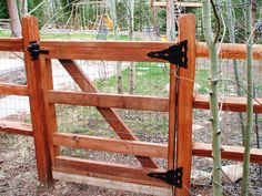 the gate is made of wood and has black iron latches on it's sides