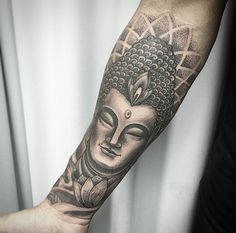 a man's arm with a buddha tattoo on the left side of his arm