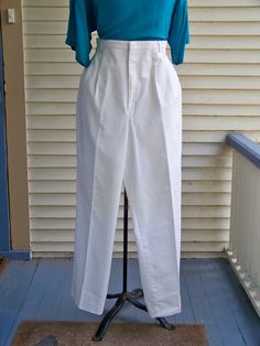 "Pleated-front trousers were popular during the 1980s. As you can see in the 2nd picture, the trousers have 4 - 6 pleats in the front for a very loose and flowy fit. The waist is at the natural waist above the hips. The tight waistline and flowy trousers make the waist seem smaller. The looseness of the trousers covers any lumps and bumps. These trousers pair well with the flowy 1980s tops. Check those out in this store. These 1980s vintage trousers are made of White Cotton/Polyester Twill fabri Vintage White Pants For Spring, White Vintage Pants For Spring, Classic Pleated Bottoms For Daywear, Vintage Spring Workwear Bottoms, Vintage High-waisted Pants For Spring, Vintage Wide Leg Pants With Elastic Waistband, Vintage High Waist White Pants, Vintage High-waist White Pants, Vintage Fitted Bottoms With Elastic Waistband