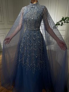 Serene Hill 2024 Blue Beaded Design A-Line Saudi Arabic Evening Dresses Gowns with Cape Sleeves for Gown With Cape, Sheer Cape, Prom Dress Inspo, Prom Inspiration, Beaded Evening Gowns, Intricate Beading, High Neck Designs, Blue Dress Formal, Unique Dress