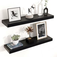 two black floating shelves with pictures and vases