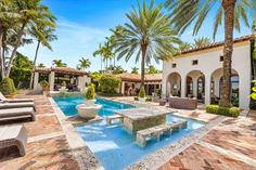 an outdoor swimming pool surrounded by palm trees and lawn furniture, with seating around it