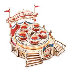 an amusement ride with lots of bowls on the table and flags flying above it that says the teacups