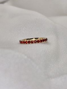 "A timeless and classic design, symbolizing commitment and love. Perfect for everyday wear or dressed up for special occasions. Make a bold statement in our Genuine Garnet Eternity Ring, handcrafted in 14k yellow gold. This ring is not adjustable and is available in US size 7 1/4.  Item Specifications: Materials: 14k Solid Yellow Gold Gemstone: Natural Garnet Total Gold Weight: 2.06 ct. Total Garnet Carat Weight: 1.22 ct.  ★  Each order will be beautifully packaged in a jewelry box and comes with a drawstring pouch that's perfect for travel. LiebeJewelry's products are handcrafted and all materials are genuine and ethically sourced. Our products are made with genuine materials and will not tarnish in the shower or irritate the skin. If you have any additional questions about this ring, jus Luxury Ruby Eternity Band As A Gift, Luxury Stackable Ruby Ring For Wedding, Elegant Ruby Eternity Band In Yellow Gold, Elegant Yellow Gold Ruby Eternity Band, Luxury Stackable Ruby Ring For Anniversary, Luxury Stackable Ruby Ring With Round Band, Elegant Ruby Gemstone Eternity Band, Elegant Red Gemstone Eternity Band, Luxury Yellow Gold Ruby Ring With Round Band