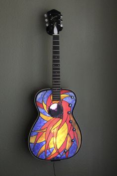 a colorful guitar hanging on the wall