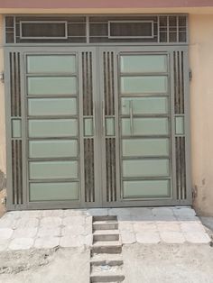 two doors are open on the side of a building with steps leading up to them