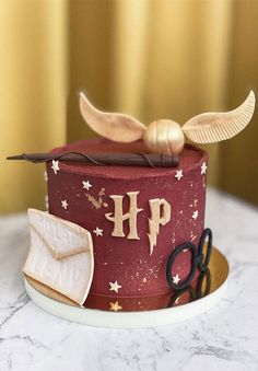 a harry potter themed cake with scissors and an open book on the top is sitting on a table