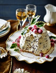 a piece of cake sitting on top of a white plate next to two wine glasses