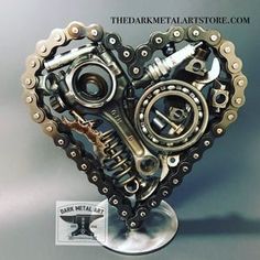 a heart shaped metal object with chains and gears attached to it's centerpiece