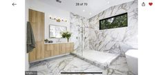 a bathroom with white marble walls and flooring, along with a walk in shower