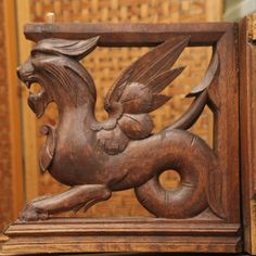 a wooden carved animal with wings on it's back