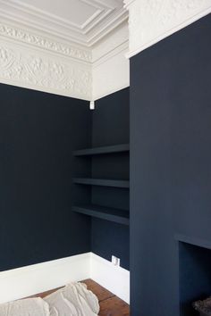 an empty room with black walls and white trim