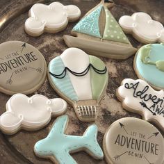 decorated cookies in the shape of boats, sailboats and other items on a plate