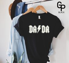 Thousands of hand-printed t-shirts. Father's Day Band Merch T-shirt With Short Sleeves, Father's Day Band Merch T-shirt, Black Unisex T-shirt For Father's Day, Unisex Black T-shirt For Father's Day, Father's Day Graphic Print T-shirt, Father's Day Unisex Graphic T-shirt, Father's Day Black Shirt With Graphic Print, Father's Day Black Graphic Print Shirt, Black Graphic Print Shirt For Father's Day