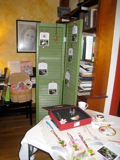 a room with a green door and pictures on the wall next to a white table