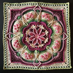 a crocheted square with pink and green flowers in the center on a black background