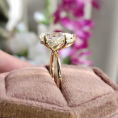 a close up of a person holding a gold ring with a diamond on the side