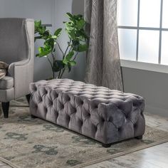 a living room scene with focus on the footstool and the chair in the foreground