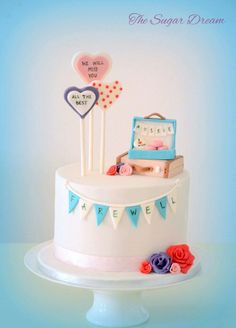 a white cake decorated with pink and blue decorations