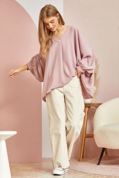 This blouse is out to prove that comfy and chic can coexist in perfect harmony. Its flowy, dolman cut gives you room to breathe while still maintaining a flattering drape. 3/4 sleeves keep it seasonal, transitioning effortlessly from summer to fall. A plunging V-neckline shows just enough skin to be subtly seductive, but the blush pink hue is as sweet and charming as an English rose garden. In short, this top lets you make a stylish statement without having to sacrifice one ounce of comfort. It’ Relaxed Fit V-neck Tunic For Fall, Flowy Blouse For Spring Loungewear, Oversized Half-sleeve Blouse For Fall, Oversized Half Sleeve Blouse For Fall, Chic Blouse For Casual Gatherings, Oversized Lantern Sleeve Blouse For Spring, Oversized Versatile V-neck Blouse, Versatile Oversized V-neck Blouse, Flowy V-neck Blouse For Fall