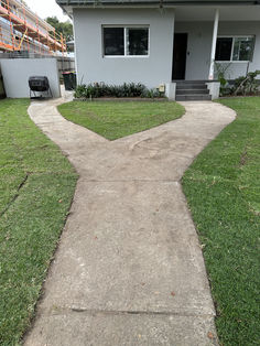 a cement walkway leading to a white house