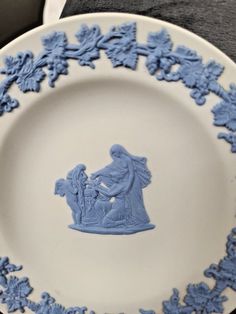 a blue and white plate with an image of a woman holding a child on it