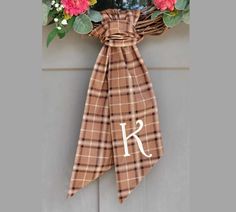 a monogrammed wreath with pink flowers hangs on the front door