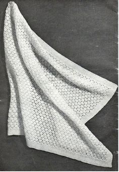 a white crocheted blanket sitting on top of a table