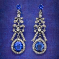 "A fabulous pair of Vintage drop earrings from the mid 20th Century decorated with glistening, brilliant cut white pastes and larger Bristol blue pastes that simulate diamonds and sapphires.  The drop galleries have an Edwardian inspired design and are crafted in a silver base metal with bows in the centre and secure screw back fittings at the top stamped with a \"Continental\" mark. They're very pretty and perfect for a wedding or glamorous occasion.  WEIGHT: 16 grams together MEASURE: Width 20 Antique Jewellery Online, Victorian Locket, Vintage Drop Earrings, Earring Box, Art Deco Earrings, Diamond Drop Earrings, Diamond Drops, Antique Earrings, Amethyst Earrings