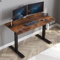 two computer monitors sitting on top of a wooden desk next to a keyboard and mouse