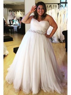 a woman in a white dress is posing for the camera