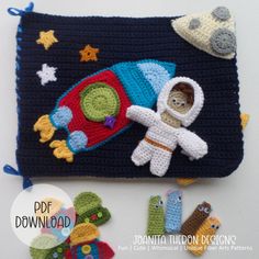 a crocheted space shuttle with an astronaut on it and other items around it