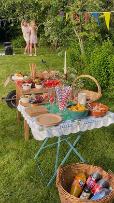 an outdoor picnic is set up with food and drinks for two people to enjoy in the grass