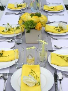 the table is set with yellow napkins and white plates