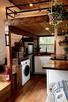 a kitchen area with a washer and dryer in the corner next to stairs