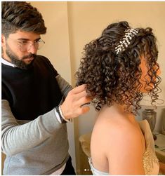 the man is cutting the woman's hair with scissors