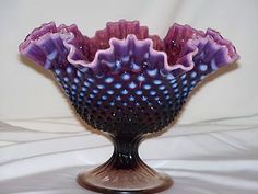 a purple vase sitting on top of a white table