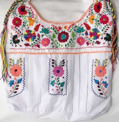 "This is a beautiful embroidered bag handmade by Mexican Artisans With elegant multi-colored designs and patterns Each embroidered bag takes about 10 hours to make Straps are made with macrame technic The strap is long enough to wear as a simple over the shoulder or as a crossbody Every bag is unique made with ancestral techniques Excellent gift for any occasion Due to the hand made nature of this item the embroidered colors and patterns may vary **HAND WASH ONLY** Follow and tag us on instagram Bohemian Bags With Multicolor Intricate Embroidery, White Cotton Bag With Floral Embroidery, White Cotton Bags With Floral Embroidery, White Cotton Shoulder Bag With Floral Embroidery, Traditional Bags With Intricate Multicolor Embroidery, Bohemian Cotton Bag With Floral Embroidery, Bohemian Cotton Bags With Floral Embroidery, Traditional Tote Bag With Floral Embroidery, Cotton Bags With Multicolor Embroidery