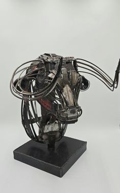 a metal sculpture sitting on top of a black base