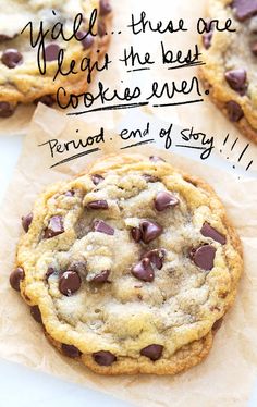 three chocolate chip cookies sitting on top of each other next to a piece of parchment paper