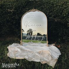 a mirror sitting on top of a grass covered field next to a white cloth covering the ground