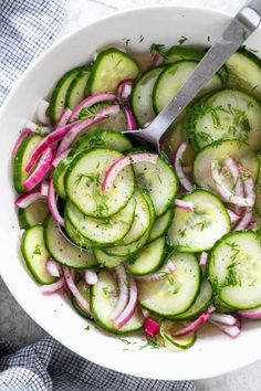 a white bowl filled with cucumbers and onions