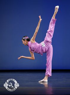 a woman in pink is doing a dance move on the stage with her legs spread out